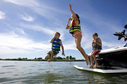 Children jump into water wearing life jackets