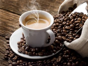 A cup of coffee surrounded by coffee beans