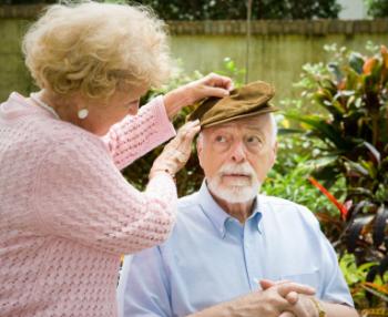 woman helping old man with his hat