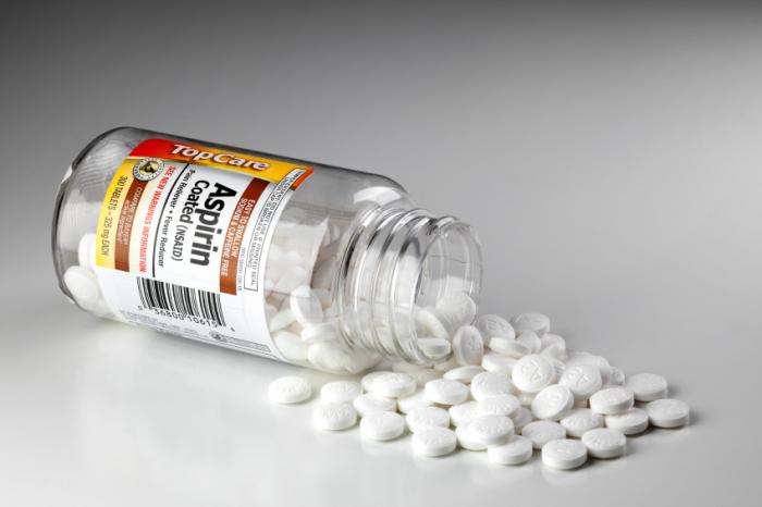 pills spilling out of a bottle of aspirin