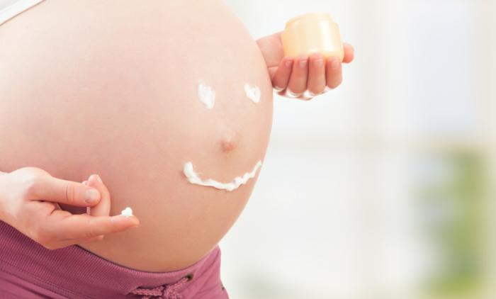 pregnant woman holding skin cream