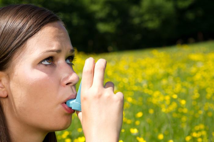 A woman with asthma using an inhaler