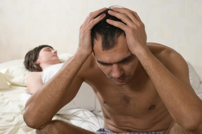 man sitting on edge of bed