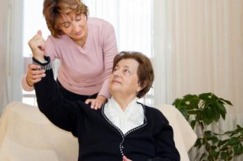 carer and lady patient raising arm