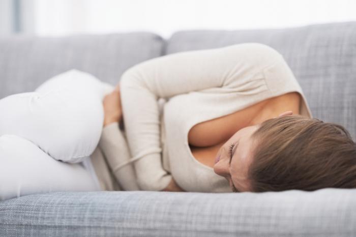 woman curled up with nausea